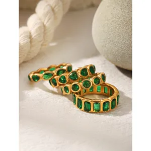 Detailed shot of trendy green zircon rings in 18k gold stainless steel, elegant stacked design.