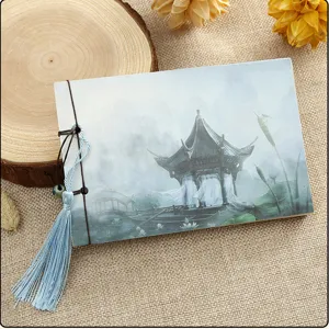 Detailed close-up of a vintage Chinese style notebook featuring a pavilion cover and tassel.