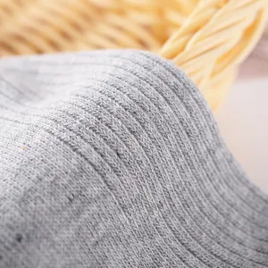 Graues Rippsocken Stoffdetail, Nahaufnahme der weichen Stricktextur für Frühling und Sommer.