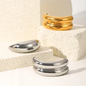 Detalle de brazalete para cabello de acero inoxidable liso con tonos dorados y plateados.