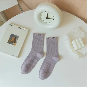 Nahaufnahme von Damen-Mittelsocken mit filigranen Rüschen-Spitzenbündchen und Feinstrick.