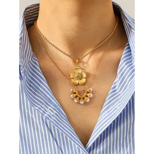 Primo piano di una collana doppia in acciaio al titanio con fiore e perla al collo.