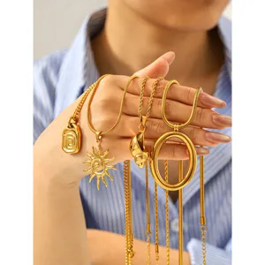 Dettaglio collana in acciaio al titanio dorato con design multi pendente su mano.