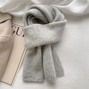 Cozy winter knitted scarf detail, solid gray soft warm fabric, elegant lazy style accessory.