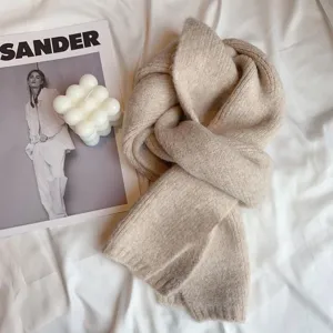 Cozy beige knit scarf detail shot, soft winter neck warmer, minimalist cold weather accessory.