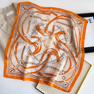 Silk scarf detail showing luxury orange equestrian belt pattern, elegant satin neck accessory.