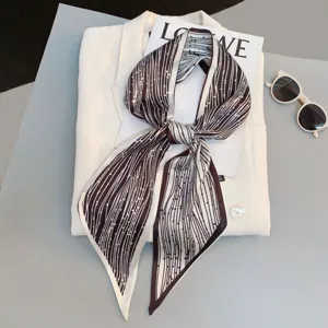 Detailed view of stylish narrow silk scarf with geometric stripe pattern, elegant neck ribbon.
