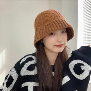 Women's thick knit winter bucket hat, cozy cable knit design, elegant warm brown headwear.