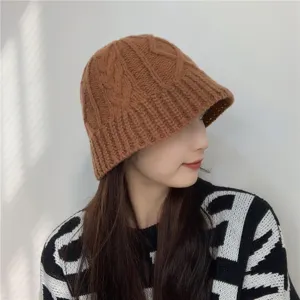 Detail view of a cozy brown cable-knit bucket hat, perfect for winter warmth and style.
