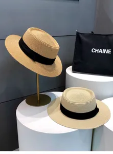Detailed view of the elegant straw boater hat featuring a stylish black ribbon band for summer.