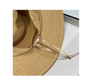 Vista di dettaglio del cappello di paglia estivo donna trama tessuta e nastro elegante.