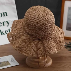Gros plan sur les détails du chapeau de paille tissé, texture naturelle et joli nœud.