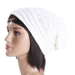 Detailed view of white knitted slouchy beanie hat, showcasing soft texture and warm design.