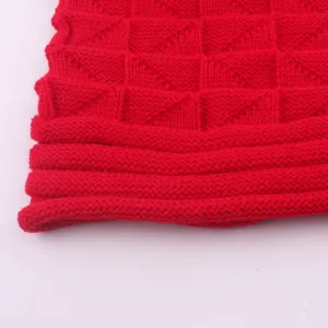 Red knit beanie hat detail view, showcasing soft winter warm woolen texture and ribbed cuffed hem design.