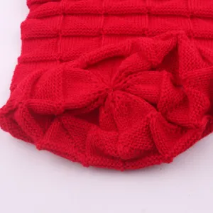 Detailed closeup of red winter knitted beanie hat showing cozy woven texture fabric.