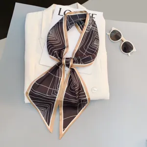 Detailed view of the elegant geometric pattern skinny scarf styled on a white blazer.