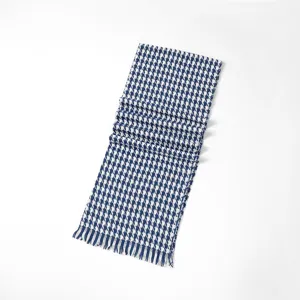 Detail view of the classic blue and white houndstooth scarf with cozy tassel winter texture