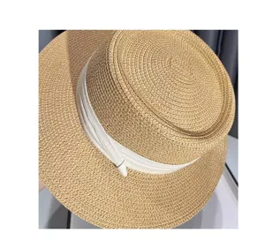 Primo piano dettagliato di un elegante cappello di paglia estivo da donna con nastro.