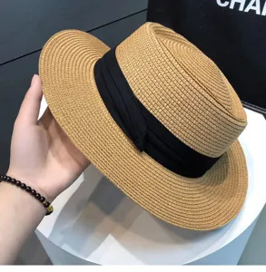 Detail shot of women summer straw hat, beige woven sun hat with black band, beach fashion.