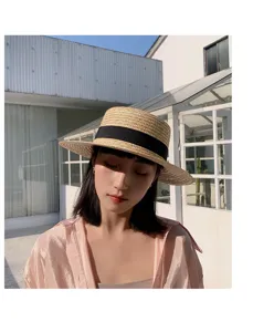 Detailed view of the stylish woven straw hat with black ribbon, perfect for summer sun protection.