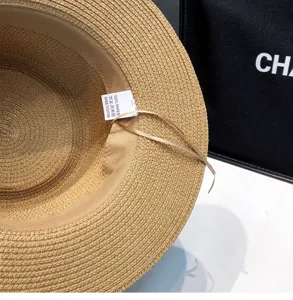 Detailed view of summer straw sun hat interior showing paper material label and beach hat design.