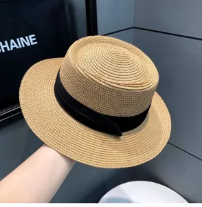Close-up detail view of women summer straw boater hat with black ribbon beach sun hat