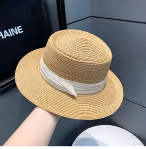 Womens summer vintage flat top straw hat with white ribbon detail, beach sun protection.