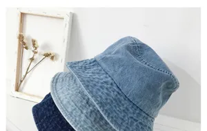 Close-up detail of stylish denim bucket hats showing soft washed texture and wide brim design.