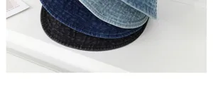 Detail shot of stacked denim bucket hats in multiple washes, showing texture and rim design.