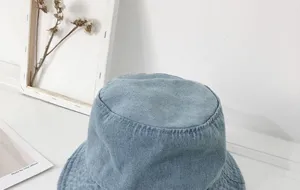 Detail view of a stylish light blue denim bucket hat, perfect for spring and summer sun protection.