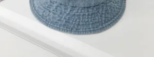 Denim bucket hat detail view, light blue casual cotton sun hat fabric texture closeup