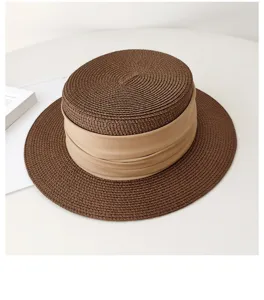 French flat-top straw hat detail showcasing fine woven texture and beige ribbon decoration.