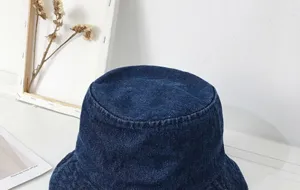 Dark blue denim bucket hat detail close-up, classic casual wide brim cotton fabric headwear.