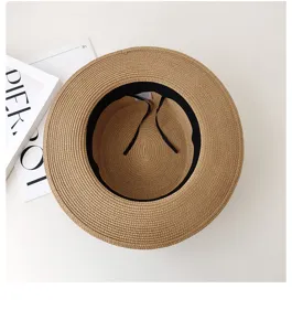 Flat top straw hat detail view showing black inner adjustable ribbon and woven texture.