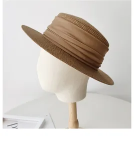 Detailed view of French flat top straw hat with wide khaki ribbon, summer sun protection.