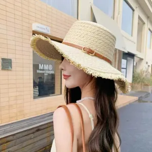 Detailed view of women's summer straw sun hat with fringe wide brim and stylish leather strap.