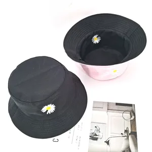 Detailansicht des wendbaren schwarzen und rosa Anglerhuts mit süsser Gänseblümchenbestickung.