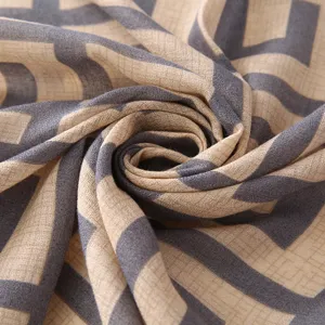 Close-up detail of geometric patterned cotton-linen scarf showing soft texture and cozy weave.