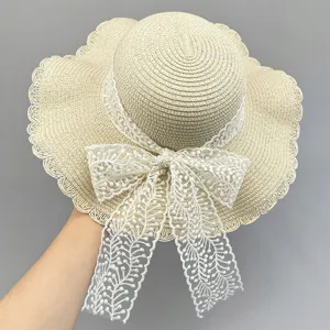 Close-up details of the summer beach straw hat featuring a delicate white lace bow.