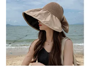 Detailed view of the wide brim sun hat with bow at the beach, showing anti-UV lining.