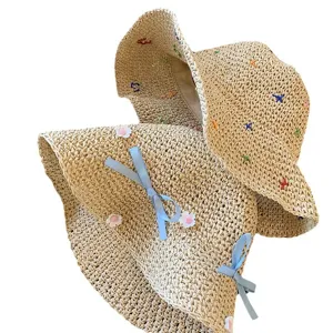 Womens straw sun hat with blue ribbon and cute flower decoration, foldable beach hat for summer.