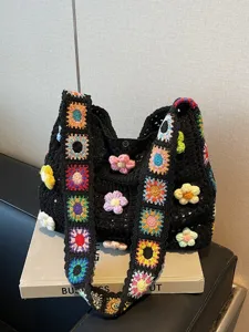 Handmade black crochet tote bag with colorful sunflower patterns for beach vacation