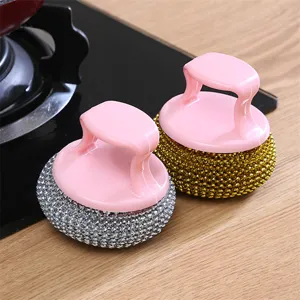 Detail view of multi-functional kitchen cleaning brush with pink handle and metallic scrub head.