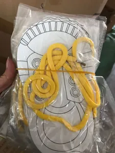 Detail shot of the shoe lacing practice toy with card and yellow lace in a clear bag.