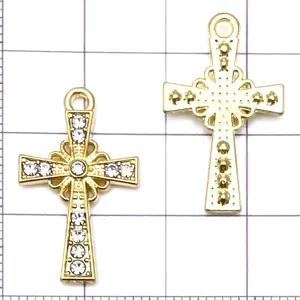 Close-up of gold cross pendant charms with rhinestones and hollow alloy design for DIY jewelry.