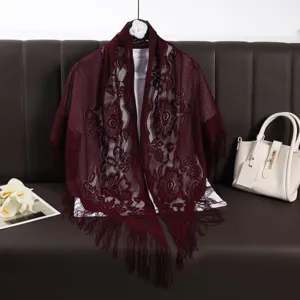 Detail of burgundy lace hollow-out fringe shawl featuring exquisite floral patterns and soft fabric.