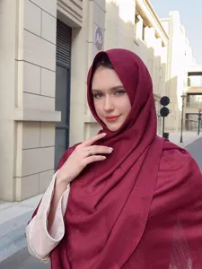 Model wearing a solid burgundy slub long scarf shawl in an outdoor urban street setting.