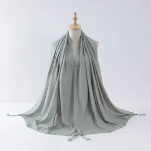 Details of the light green tassel hijab featuring elegant silver wire edges and wooden beads.