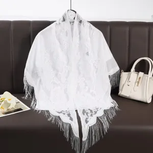 Close-up detail of white lace fringe shawl with hollow floral pattern, elegant and breathable.