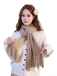 Close-up detail view of the soft knitted fuzzy winter scarf featuring elegant fringe trim.